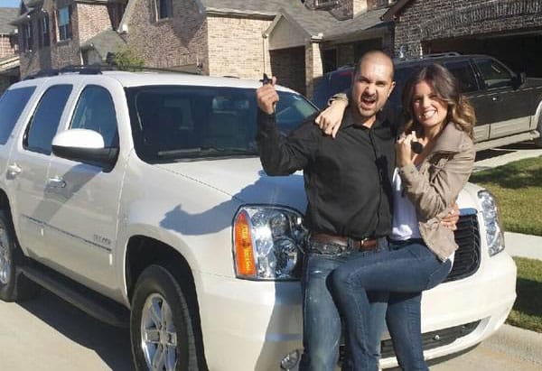 Couple posed in front of new white suv car lease